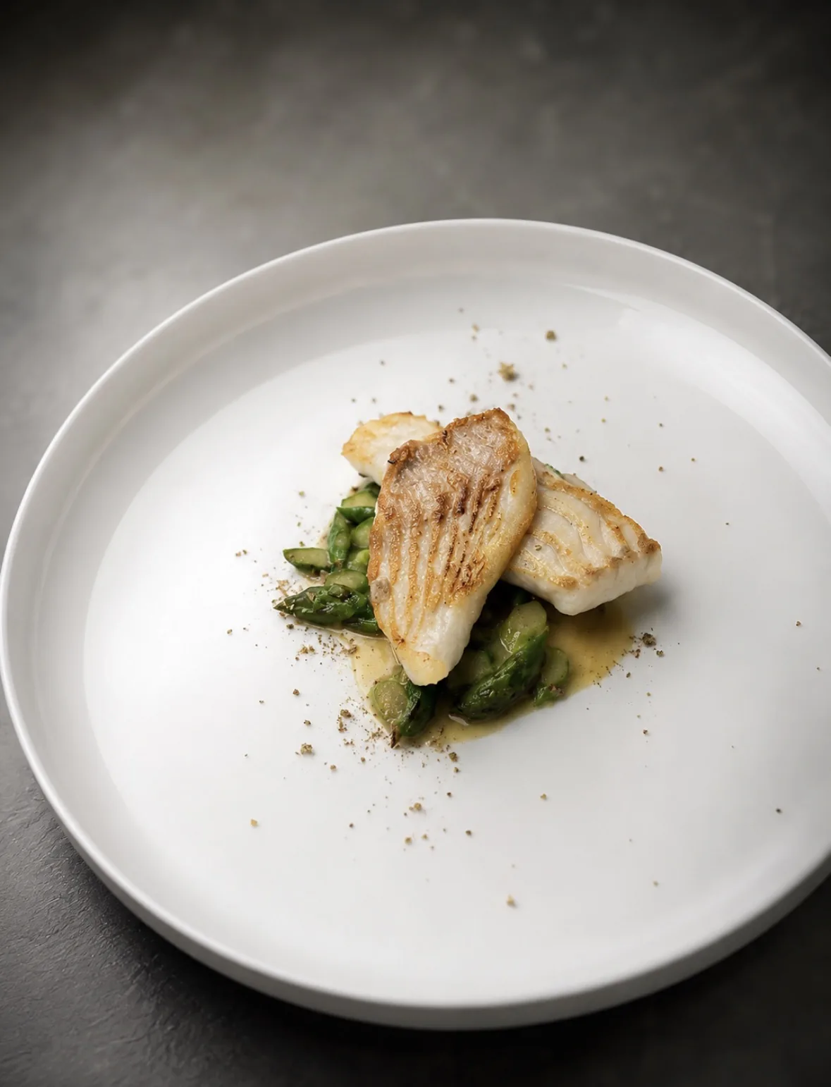 Seared fish fillet on asparagus with olive oil emulsion