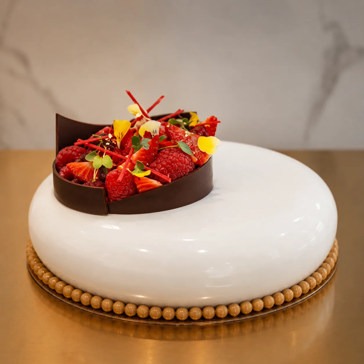 White chocolate dome with fresh berries and edible flowers