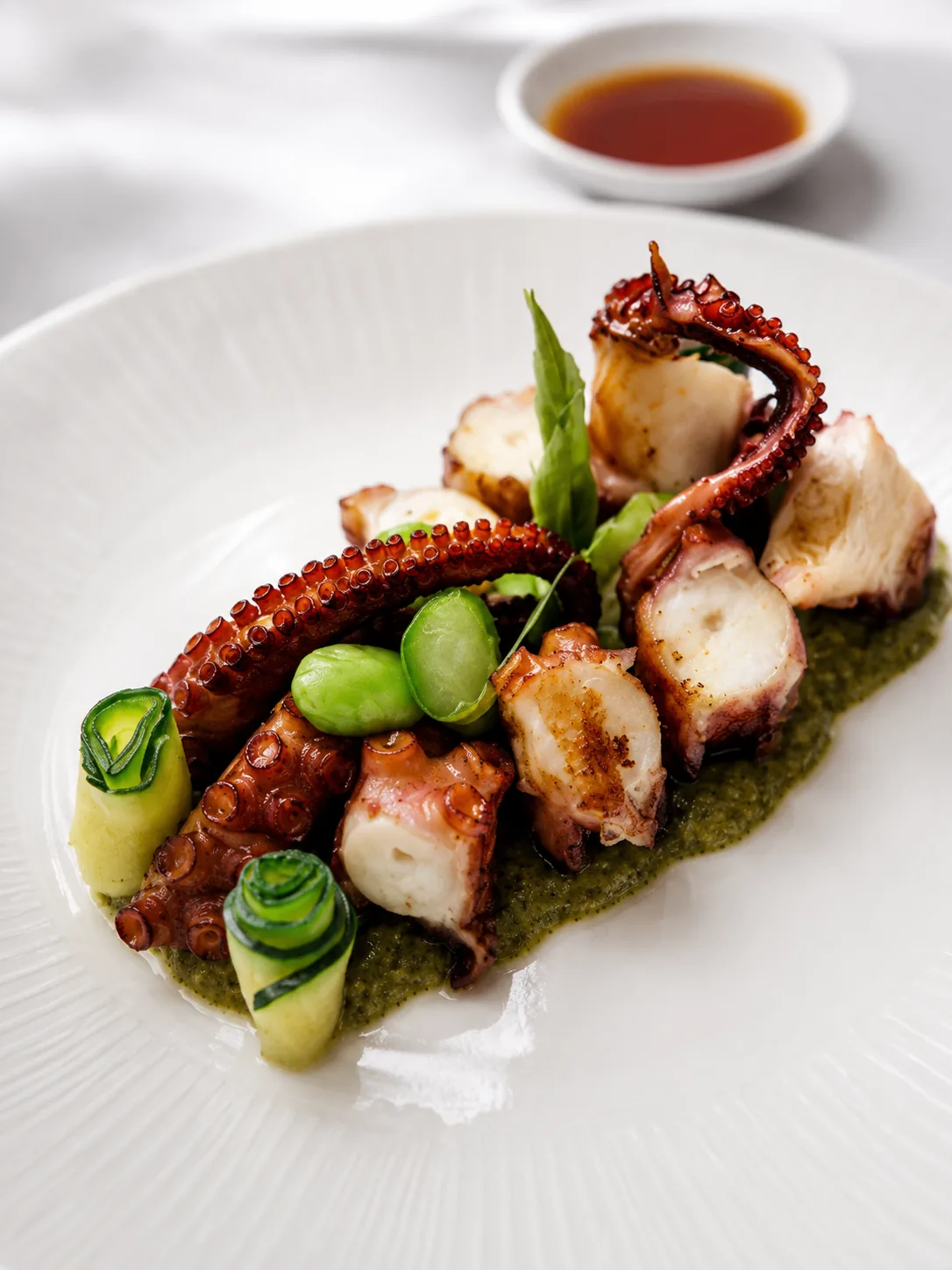 Grilled octopus with herb purée and broad beans