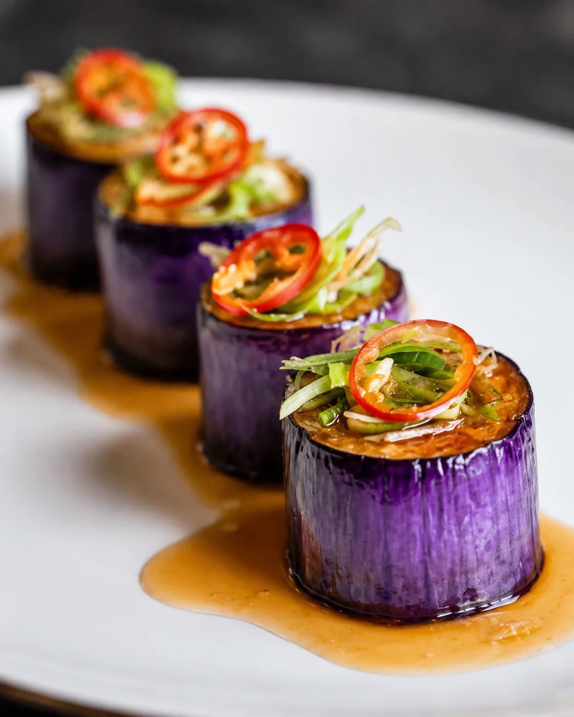 Glazed purple potato cylinders with chili and herbs