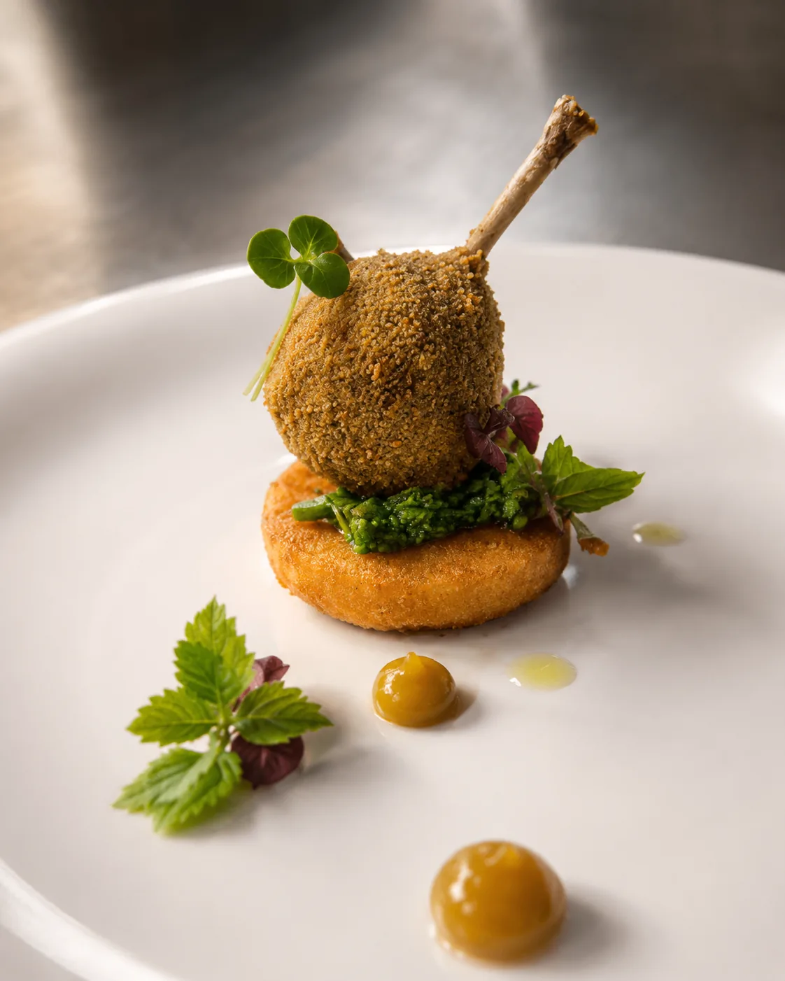Crispy lamb lollipop on herb fritter with glossy mustard